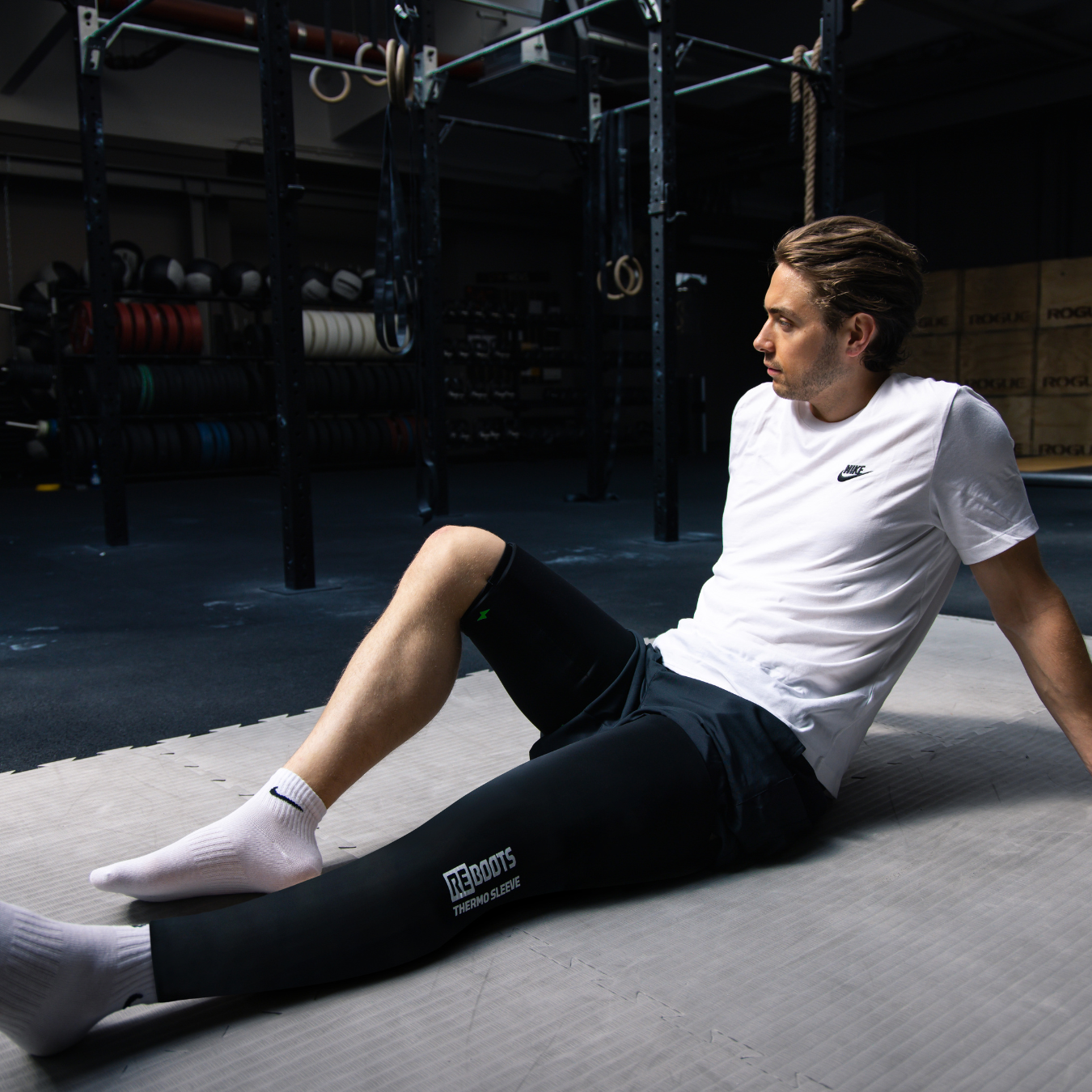 Reboots: Persona con camiseta blanca sentado con Thermo sleeves dobles, manguitos térmicos de pierna completa, terapia de frío y calor para tu recuperación.
