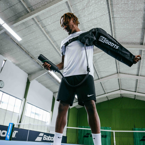Reboots: Farbige Tennisspielerin, die ihren Arm mit der Sport-Drucktherapie GO LITE wiederherstellt.