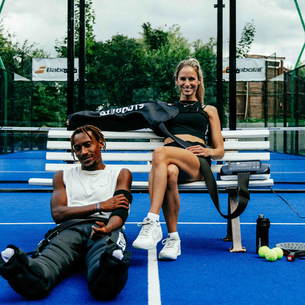 Reboots: Tennispaar sitzt und erholt sich mit Drucktherapie für Beine und Arme