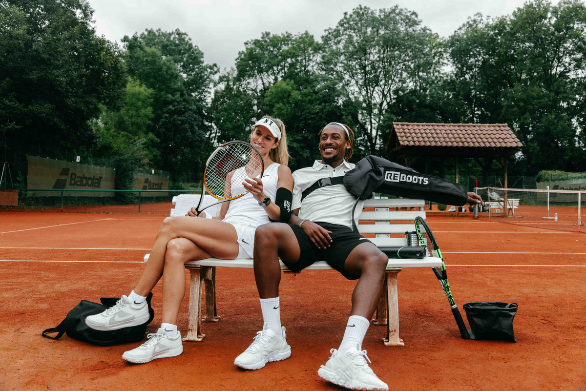 Tennisspielerpaar mit Reboots-Druckmanschetten.