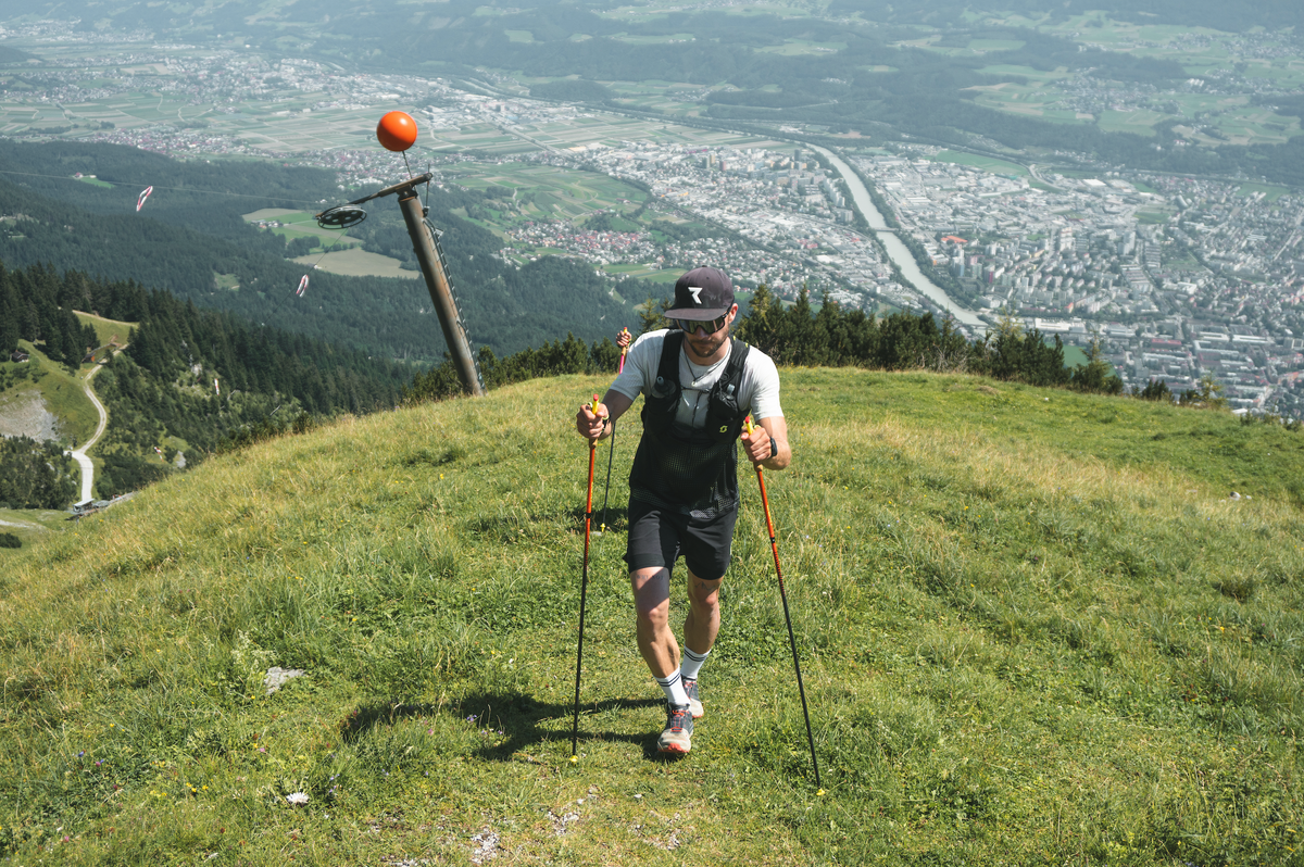 Sportlicher Mann beim Bergtraining mit Trekkingstöcken – aktive Erholung und Ausdauertraining in der Natur mit Reboots Recovery im Fokus für optimale Regeneration.