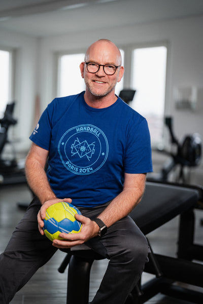 Reboots: Mann mit Handball auf Trainingsbank