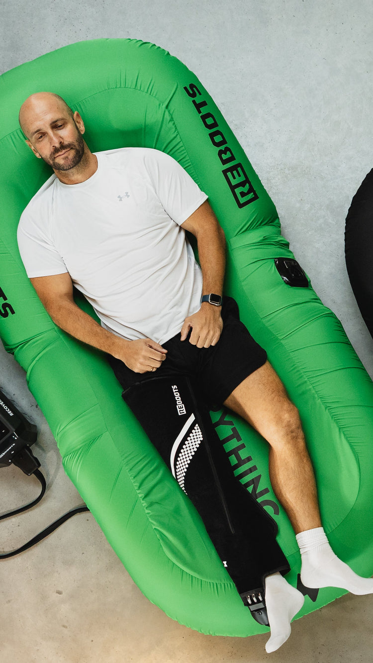 Sportler entspannt mit Reboots Recovery Cryo System auf grünem Reboots Liegesessel.