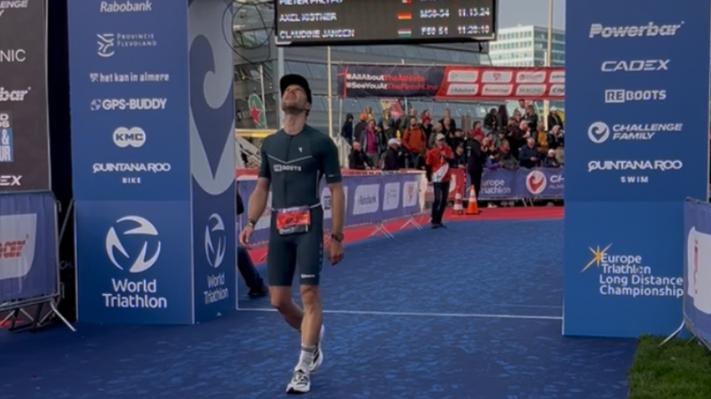 Triathlet im Ziel nach einer Langdistanz.