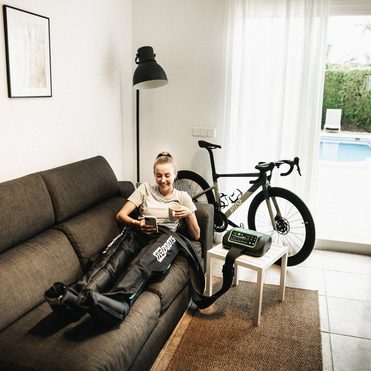 Frau nutzt Reboots Kompressionsmassage auf dem Sofa. 