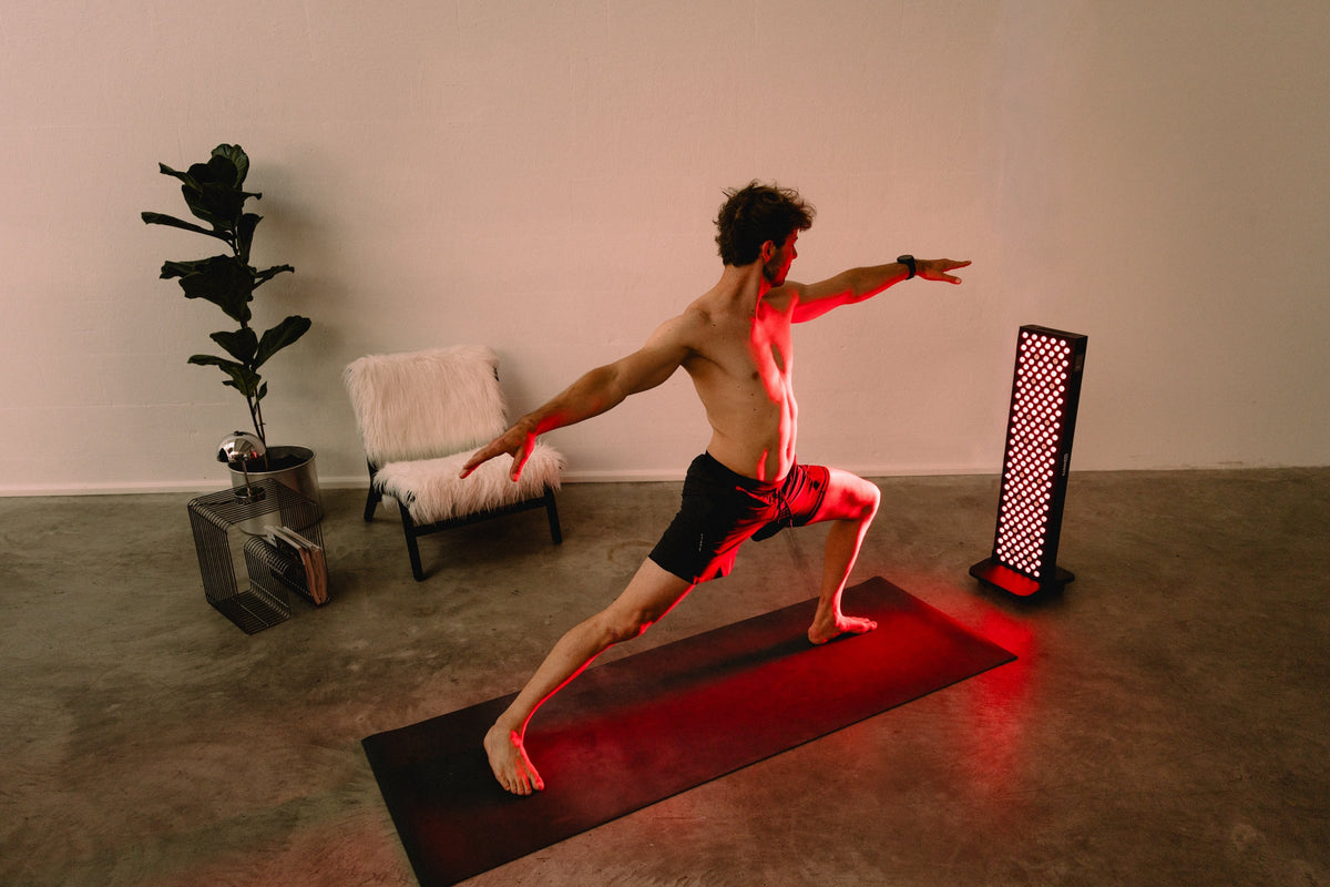 Reboots Relight Pro Standleuchte – Yoga-Übung in Kriegerstellung während der Rotlichttherapie zu Hause
