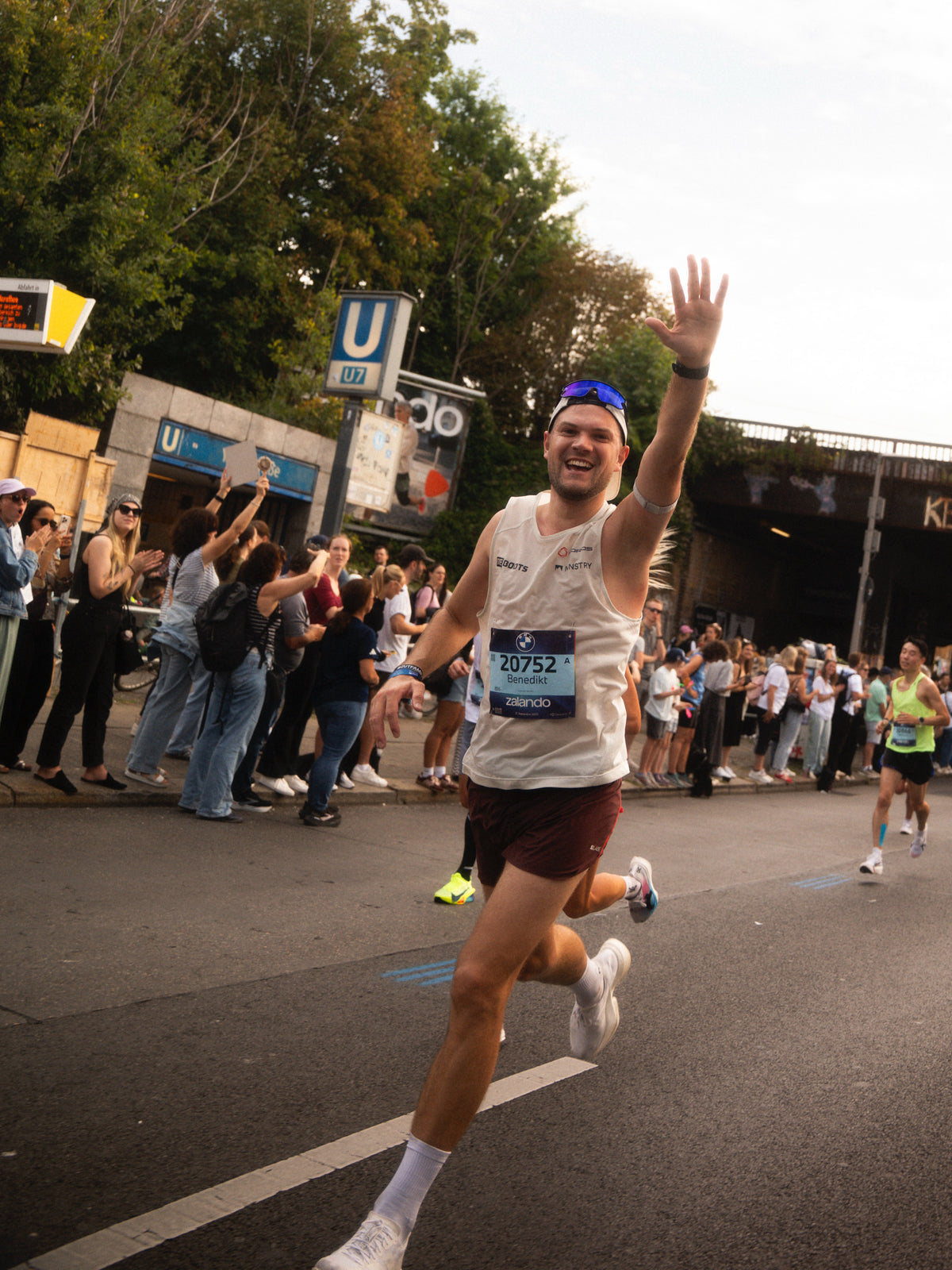Benedikt Jany vom Reboots Athletes Project beim Berlin Marathon, jubelnd auf der Strecke vor begeistertem Publikum.