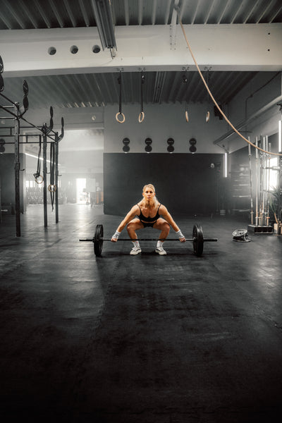 CrossFit-Athletin hebt eine Langhantel beim Kreuzheben im Gym