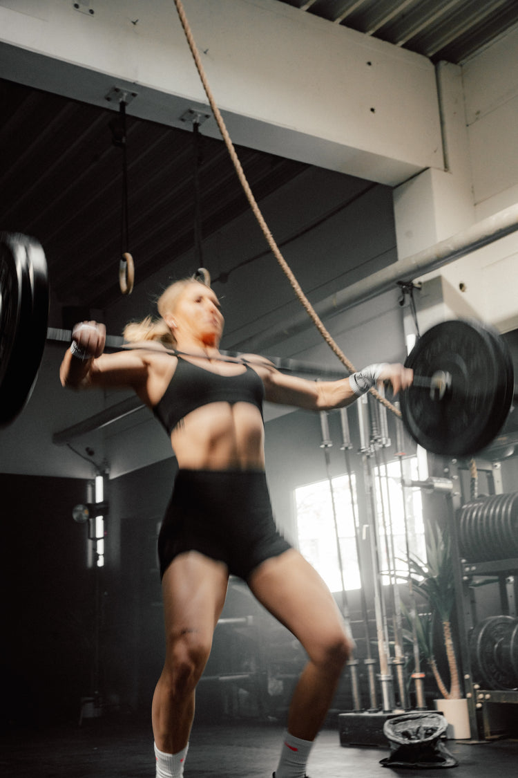 Cross Fitterin stemmt Gewichte. 