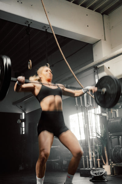 CrossFit-Athletin Anna Donauer beim intensiven Functional-Fitness-Training mit Langhantel im Gym