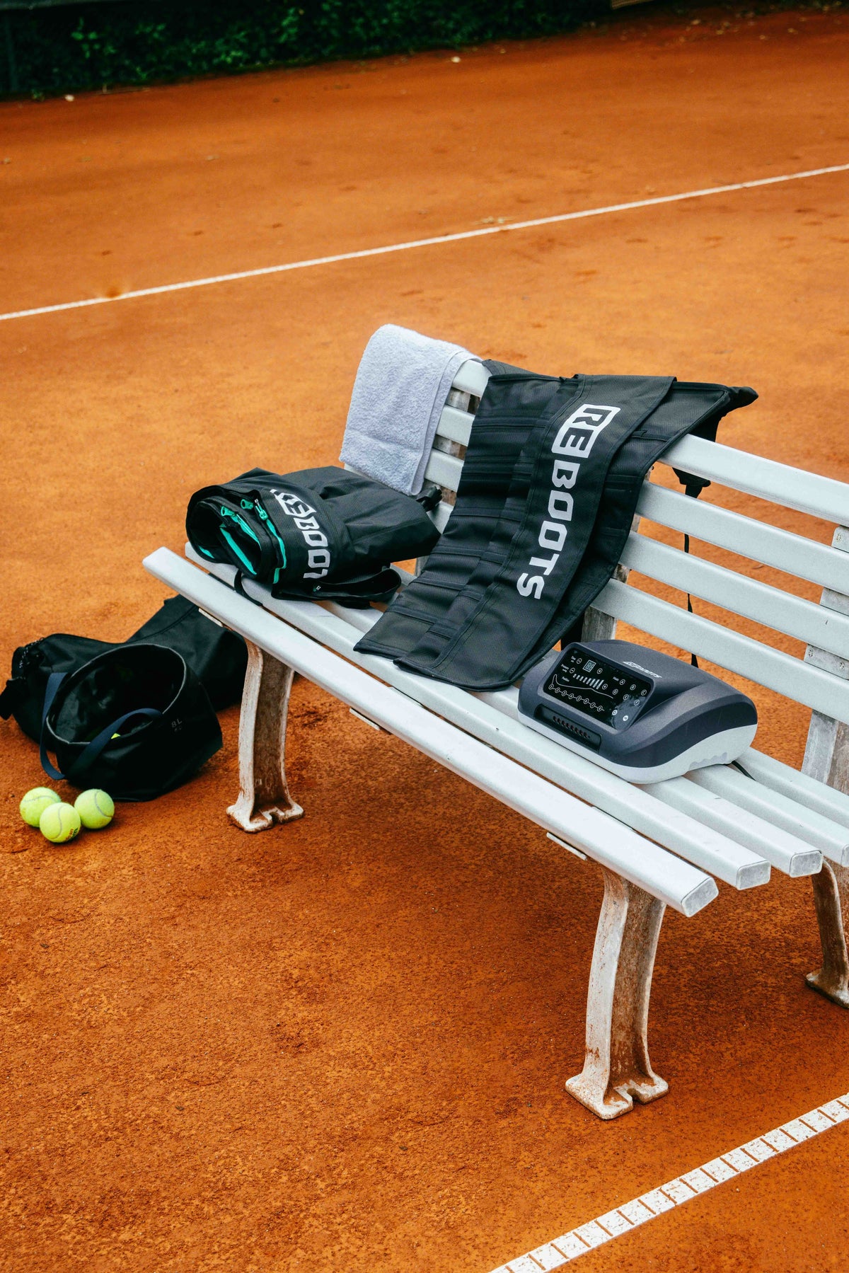 Reboots: Armcuffs und Reboots Pants auf Bank, Tennisplatz