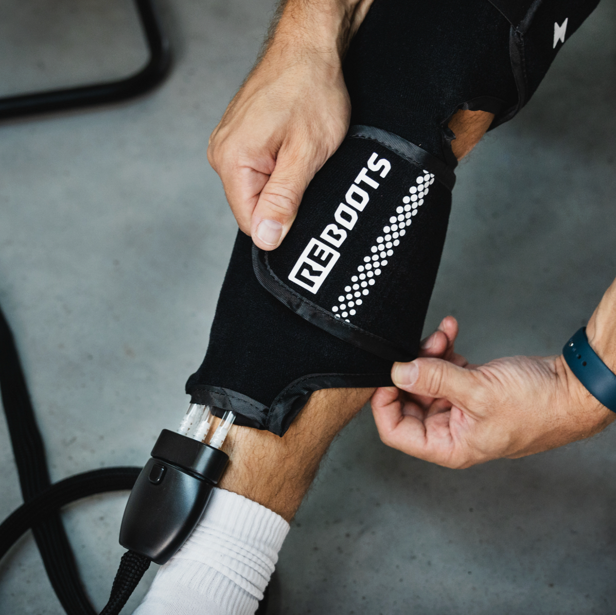 Athlet legt die Reboots Cryo Pro Manschette am Bein an – gezielte Kälte- und Kompressionstherapie zur Regeneration und Linderung von Schmerzen nach dem Training.