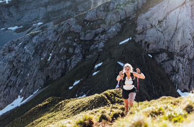 Trailrunnerin beim Berglauf in alpiner Landschaft – intensive Ausdauerbelastung im Outdoor-Training