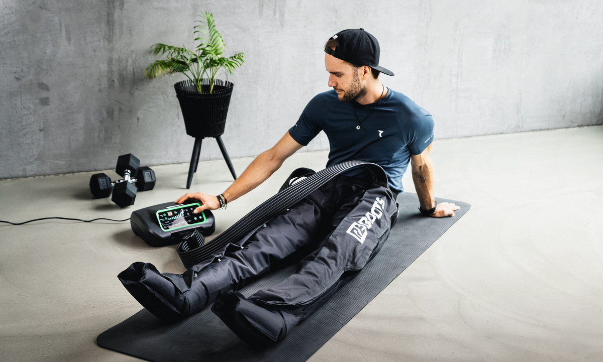 Athlet verwendet Reboots One Kompressionsmassage zur Beinregeneration nach dem Workout