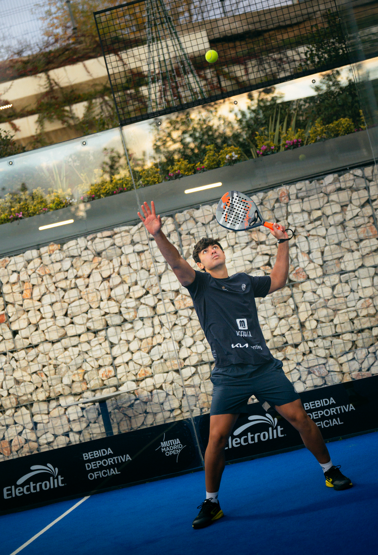 Profi-Padelspieler beim Aufschlag auf dem Court – intensives Match beim Mutua Madrid Open, Performance und Regeneration mit Reboots im Profisport