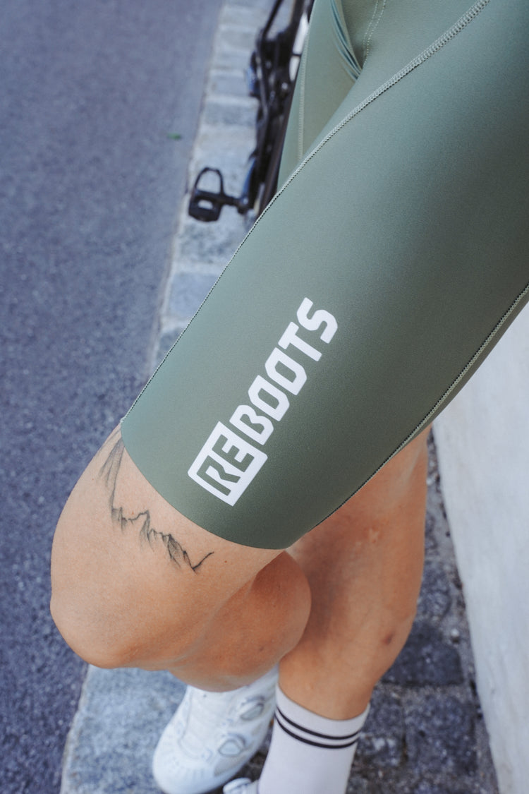 Detailaufnahme der Reboots Bike Bib aus der Move & Recover Collection mit REBOOTS Logo auf dem Bein