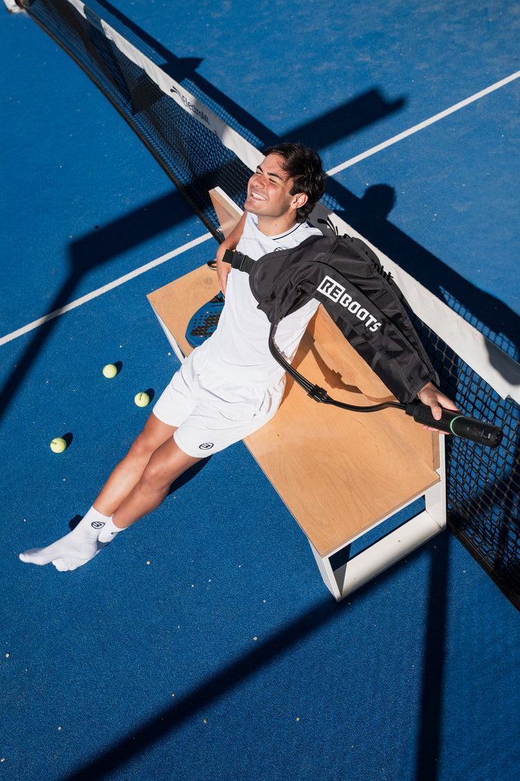 Pablo Cardona nutzt die Reboots Kompressionsstiefel zur Regeneration auf dem Padel-Court