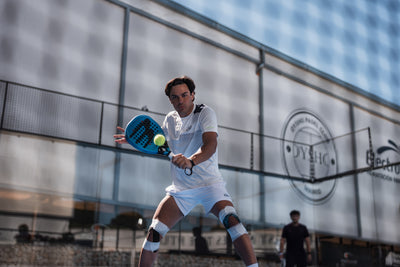Padel-Spieler trifft den Ball mit der Rückhand auf dem Court