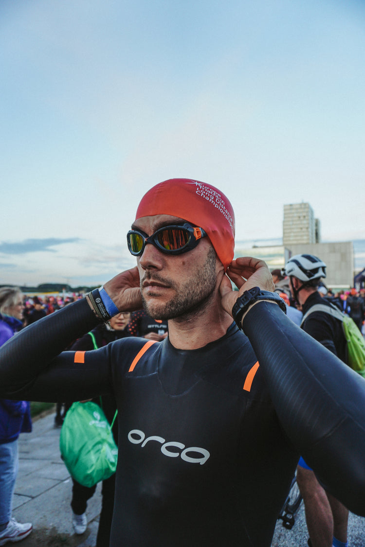 Triathlet mit Neoprenanzug und Schwimmbrille vor dem Wettkampf – Vorbereitung auf den Schwimmstart bei einem Triathlon-Event
