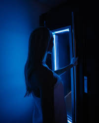 Person öffnet eine blau beleuchtete Kryokammer für eine Ganzkörper-Kältetherapie – moderne Cryo-Anwendung zur Regeneration und Leistungssteigerung.