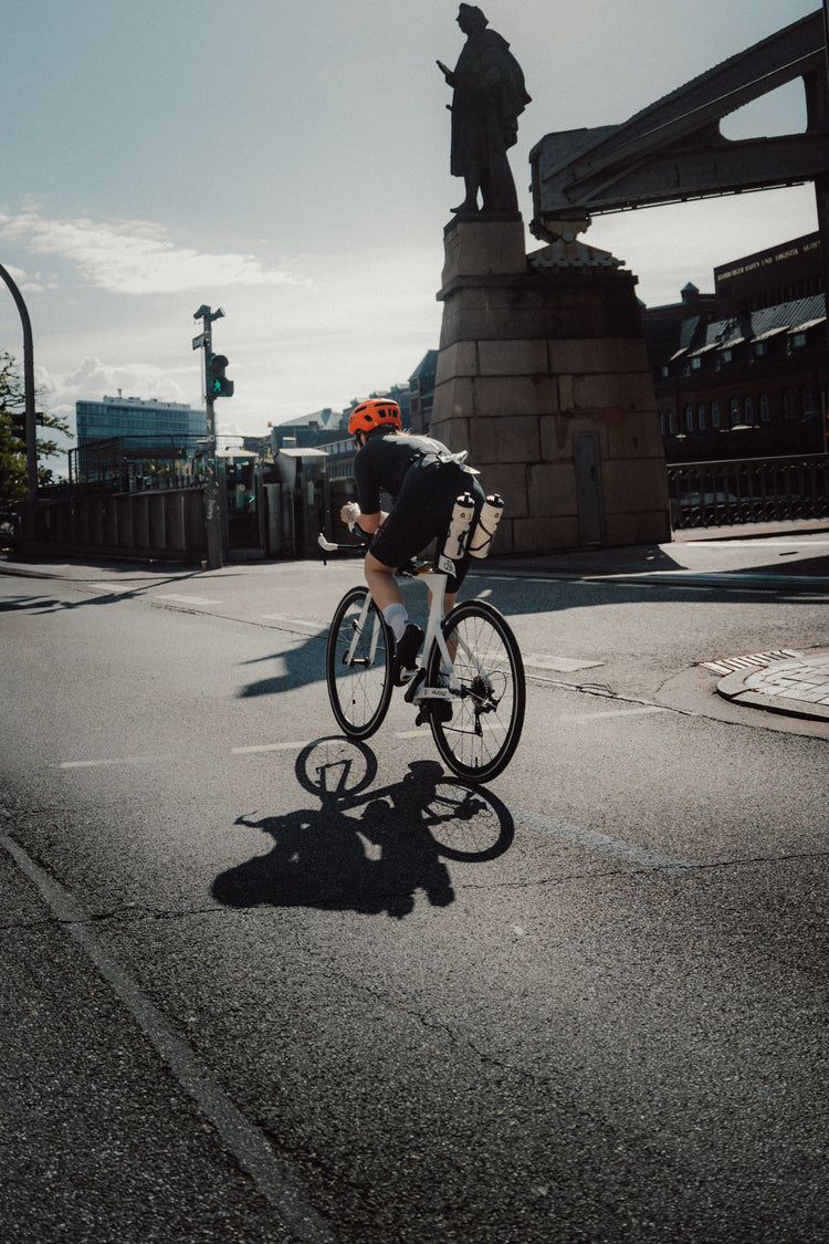 Triathletin fährt auf dem Rennrad beim Ironman durch die Stadt.