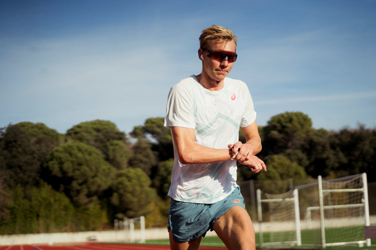 Triathlet Jonas Schomburg absolviert eine Laufeinheit auf der Laufbahn und überprüft während des Trainings seine Sportuhr.