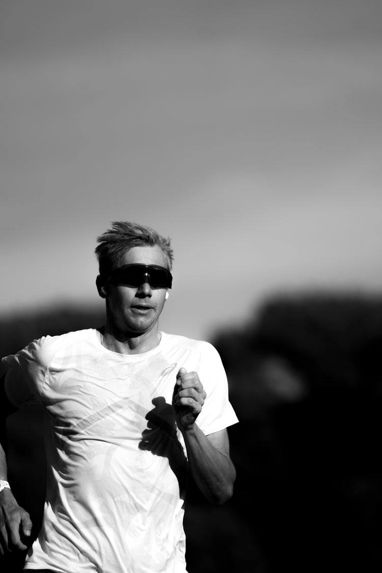 Schwarz-Weiß-Porträt eines Läufers im Intervalltraining – Fokus, Schnelligkeit und Ausdauer im Leistungssport.