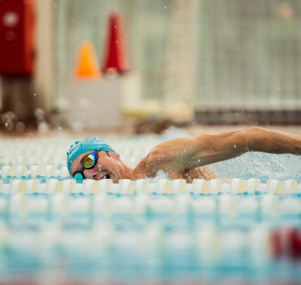 Triathlet beim Schwimmen im Becken – intensives Ausdauertraining und optimale Regeneration für Triathlon“