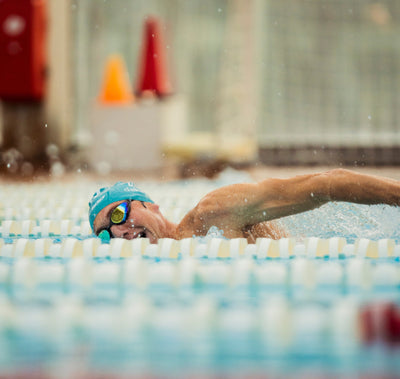 Triathlet beim Schwimmen im Becken – intensives Ausdauertraining und optimale Regeneration für Triathlon“
