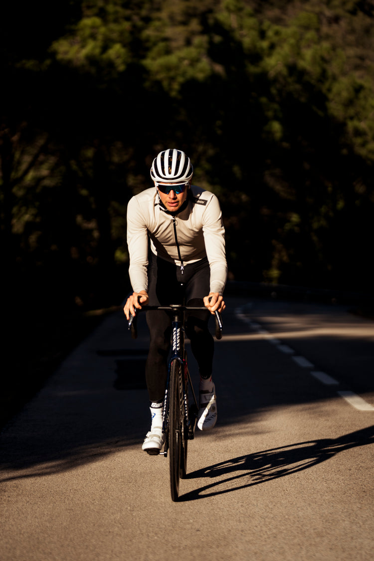 Triathlet Jonas Schomburg fährt eine intensive Trainingseinheit auf dem Rennrad auf einer ruhigen Straße während seiner Triathlonvorbereitung.