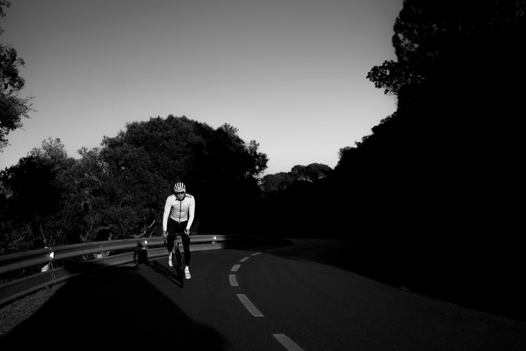 Radfahrer beim Training auf der Straße in bergiger Landschaft