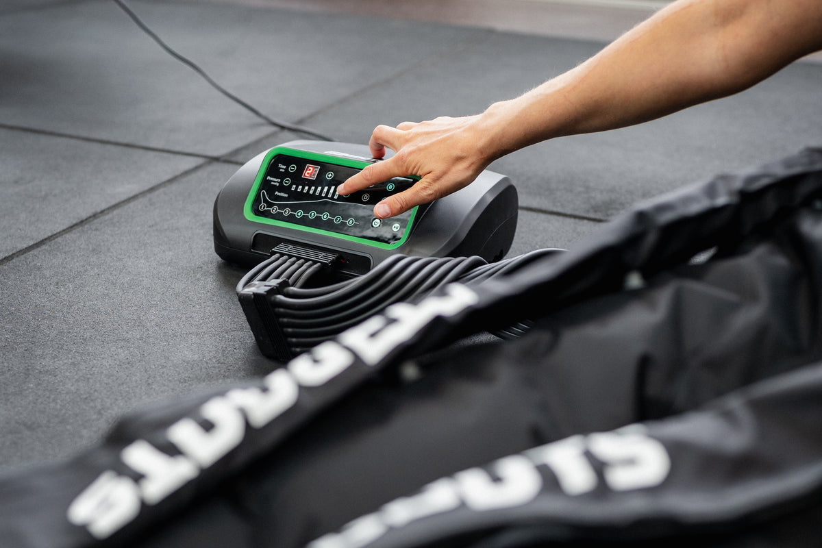 Reboots One Lite Steuergerät wird per Hand bedient – mobiles Kompressionsmassagegerät für effektive Regeneration der Beine.