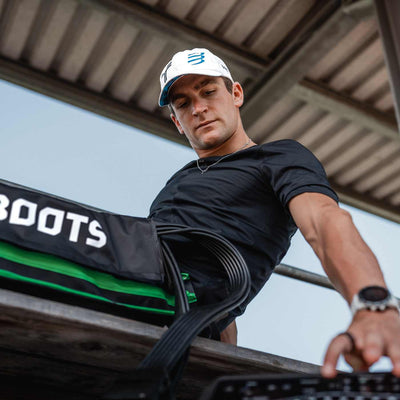 Reboots: Frederick Funk mit Mütze, sitzend und sich mit Reboots-Drucktherapie erholend