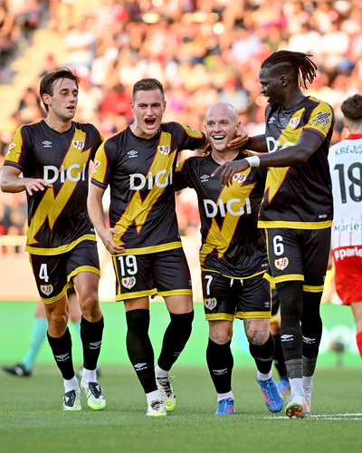 Mehrere Spieler von Rayo Vallecano im schwarzen Auswärtstrikot jubeln nach einem Tor während eines Fußballspiels.