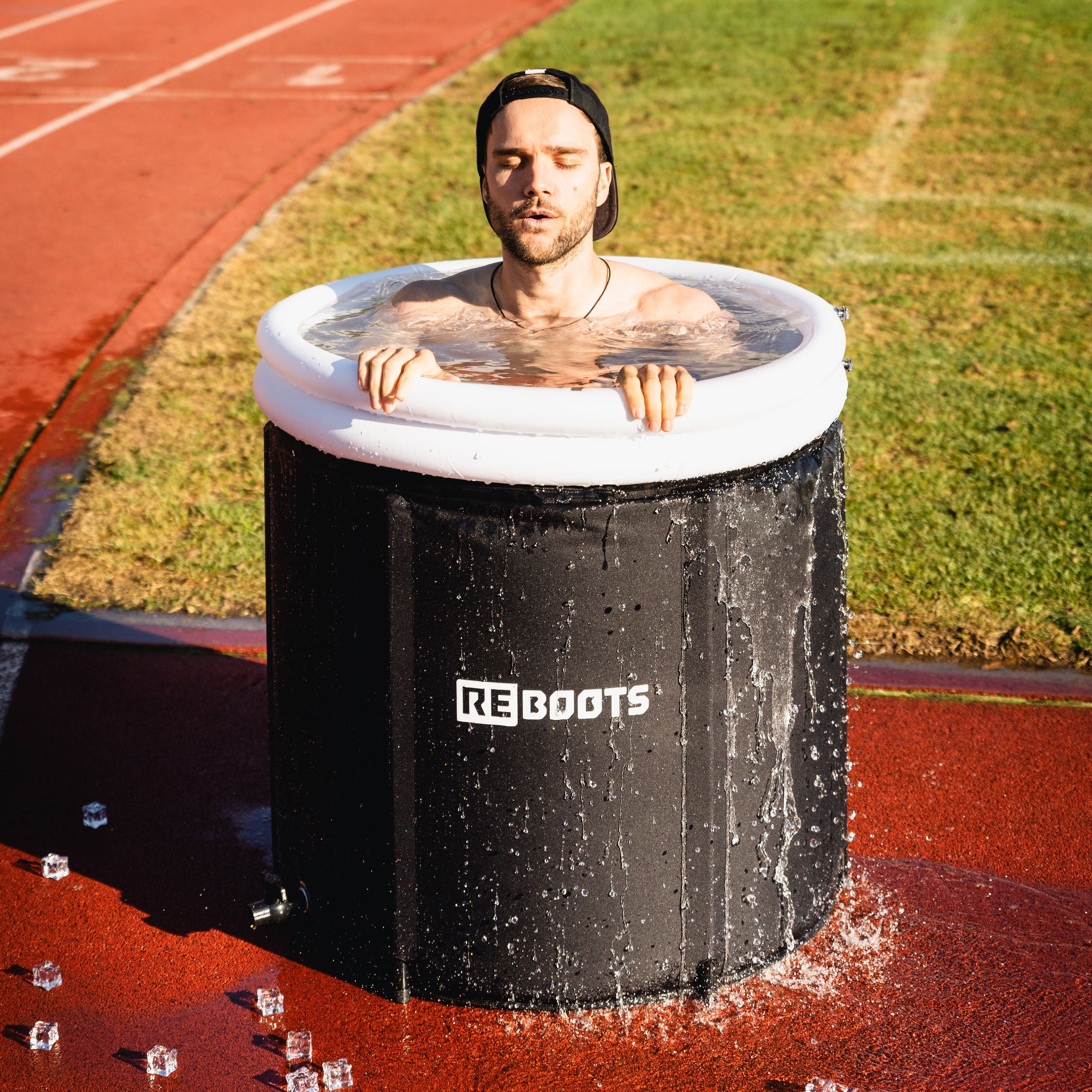 Sportler nimmt ein Kältebad im Reboots Ice Tub auf der Laufbahn – optimale Regeneration, Muskelkühlung und Erholung nach dem Sport.