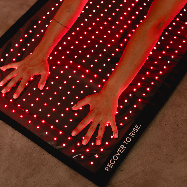 Hände auf der Reboots Relight Mat mit dem Schriftzug Recover to Rise