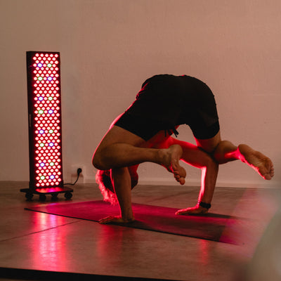 Mann übt eine Yoga-Balance-Pose vor dem Reboots Relight Pro Rotlichtpanel