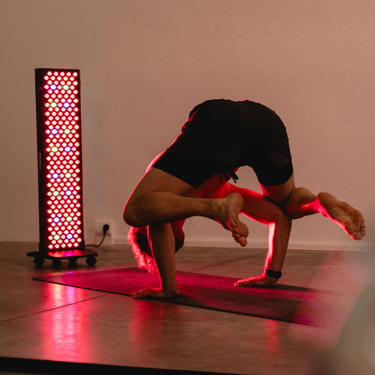 Mann übt eine Yoga-Balance-Pose vor dem Reboots Relight Pro Rotlichtpanel
