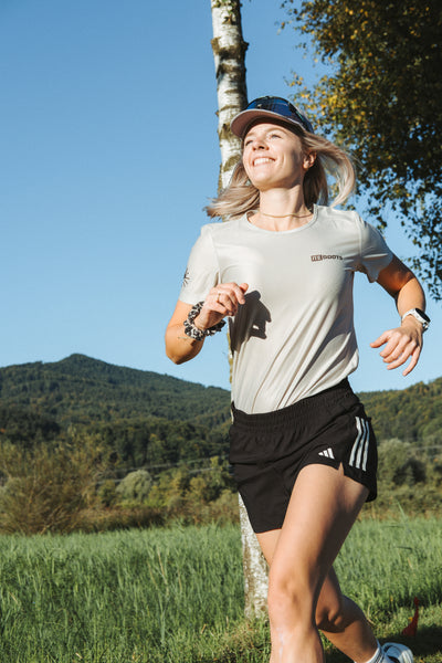 Athletin trägt das Reboots Running Shirt beim Laufen – funktionales, leichtes Sportshirt für Komfort und Performance im Training.