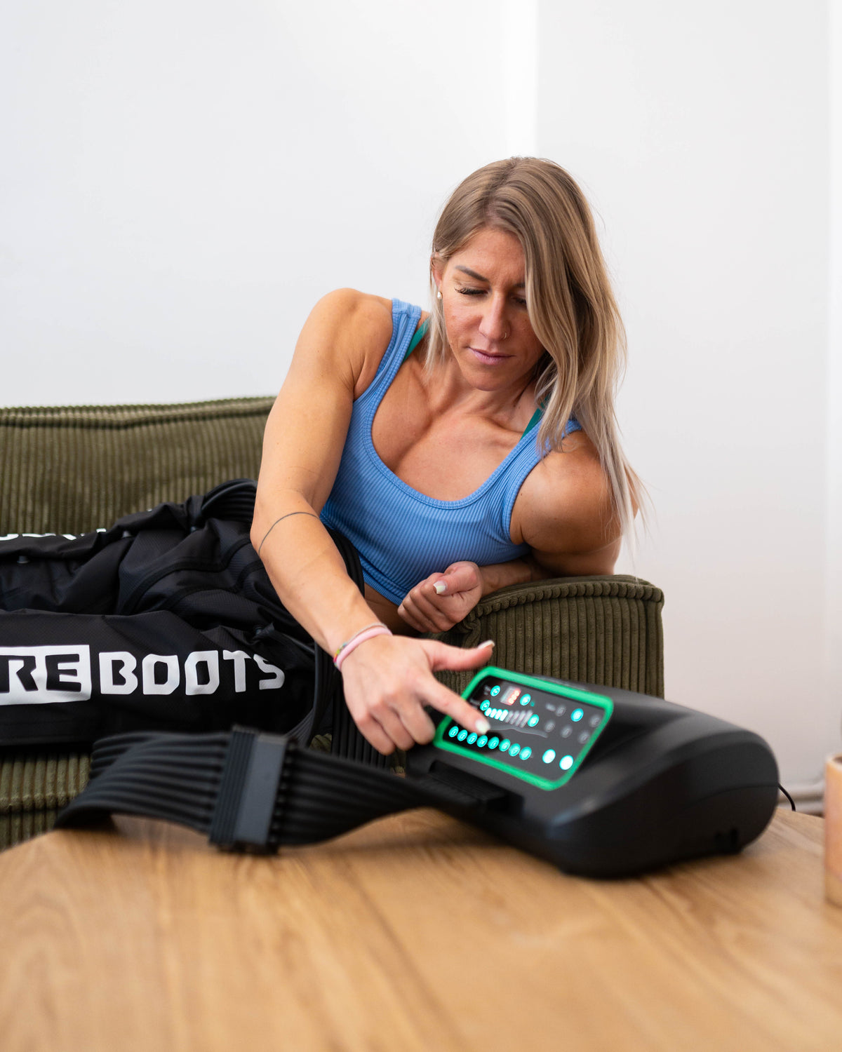 Reboots: Sportlerin auf Sofa mit Reboots Pants an den Beinen