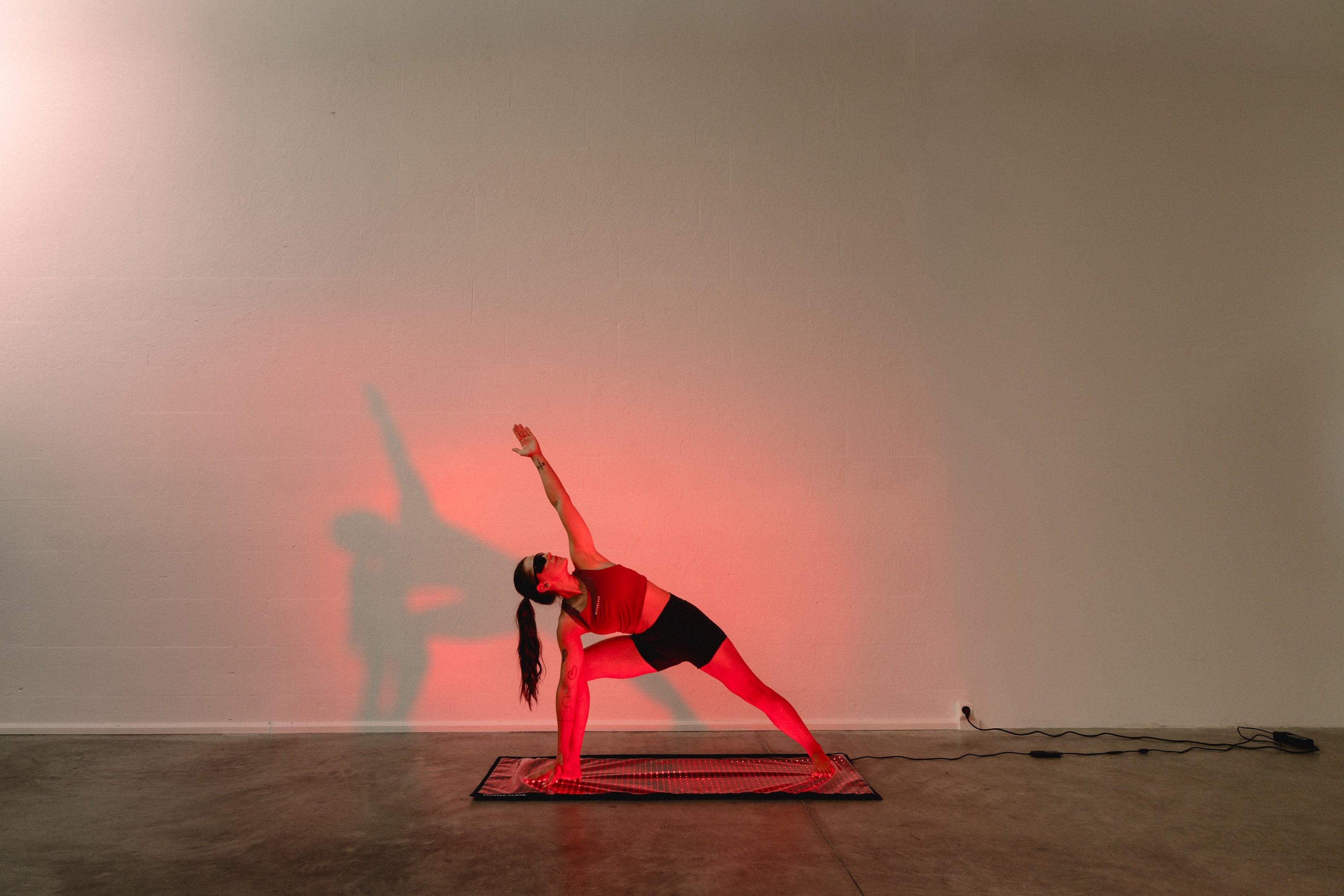 Reboots Relight Mat – Yoga-Dreieckshaltung während der Rotlichttherapie mit Schutzbrille