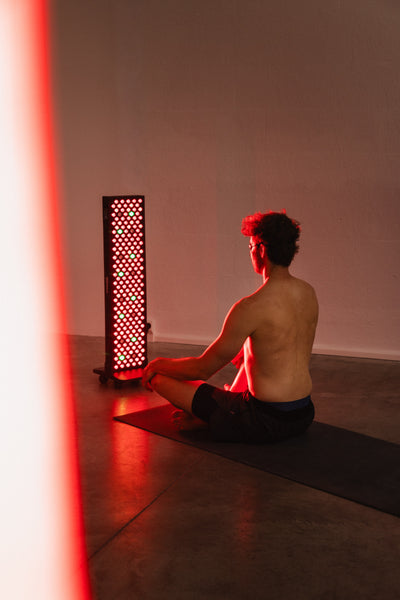 Reboots Relight Pro – Meditation im Schneidersitz vor dem Rotlichtpaneel auf der Matte