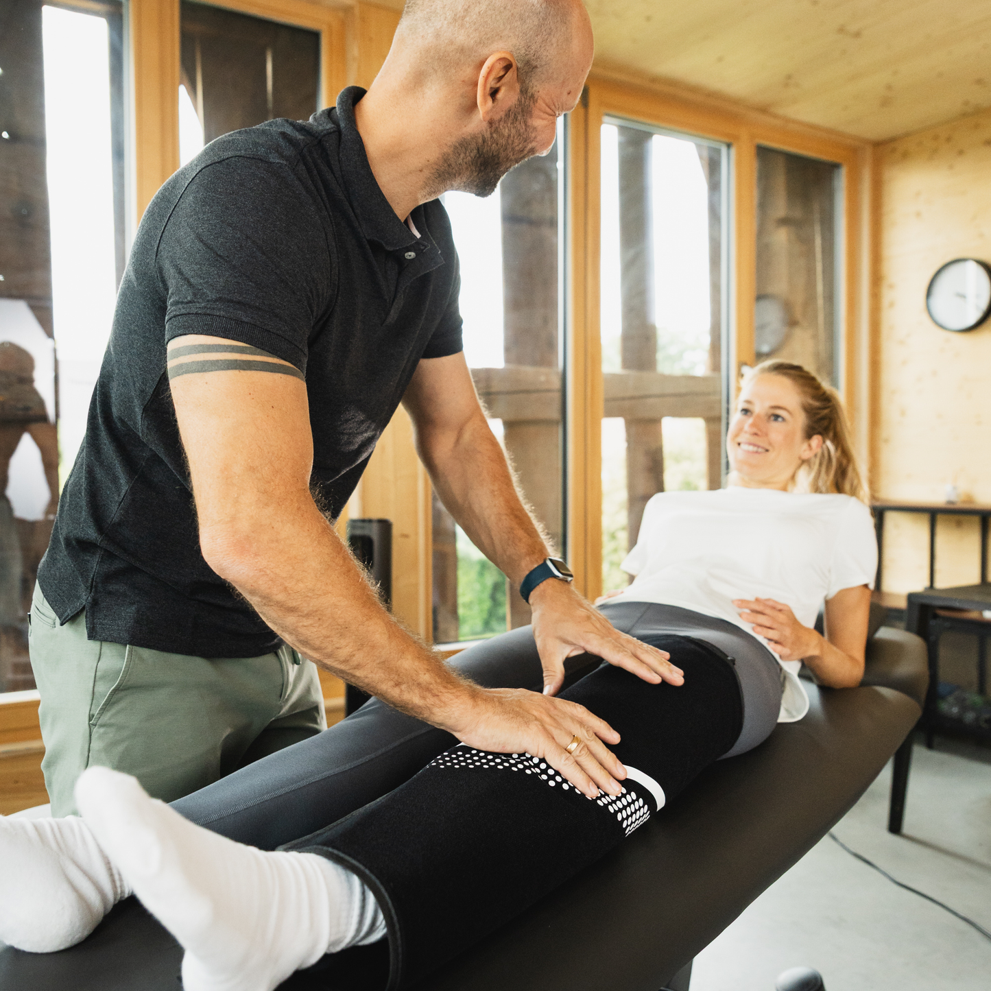 Un fisioterapeuta utiliza el Reboots Cryo Pro con el dispositivo de manguito para piernas en una paciente.