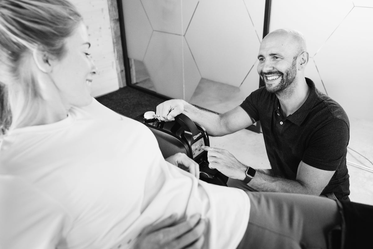 Therapeut stellt Reboots Cryo Pro Kälte- und Kompressionstherapie für eine Sportlerin zur gezielten Regeneration nach dem Training ein.