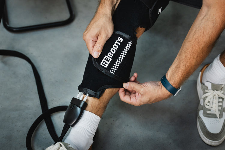 Athlet legt ein Reboots Cryo Pro Sleeve am Unterschenkel an – Vorbereitung für gezielte Kälte- und Kompressionsbehandlung.