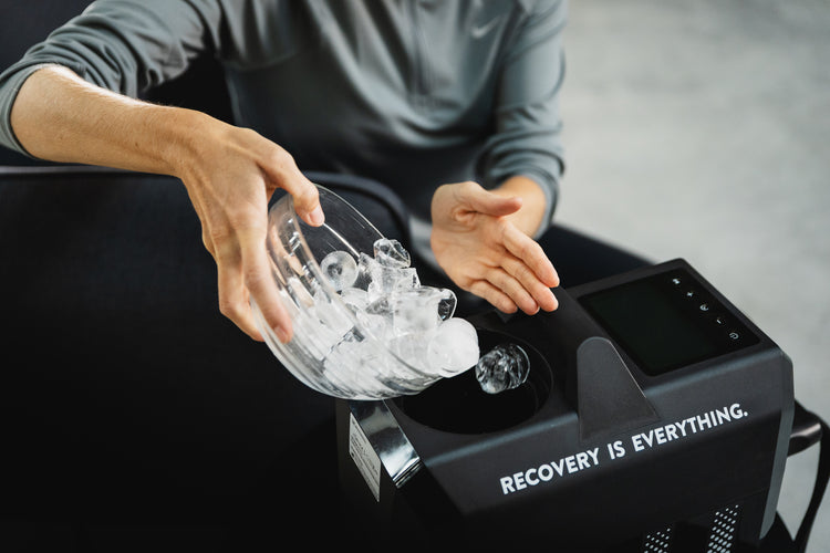 Person füllt Eiswürfel in das Reboots Cryo One Gerät – Vorbereitung einer Kältetherapie für gezielte Regeneration und Schmerzlinderung nach dem Training.