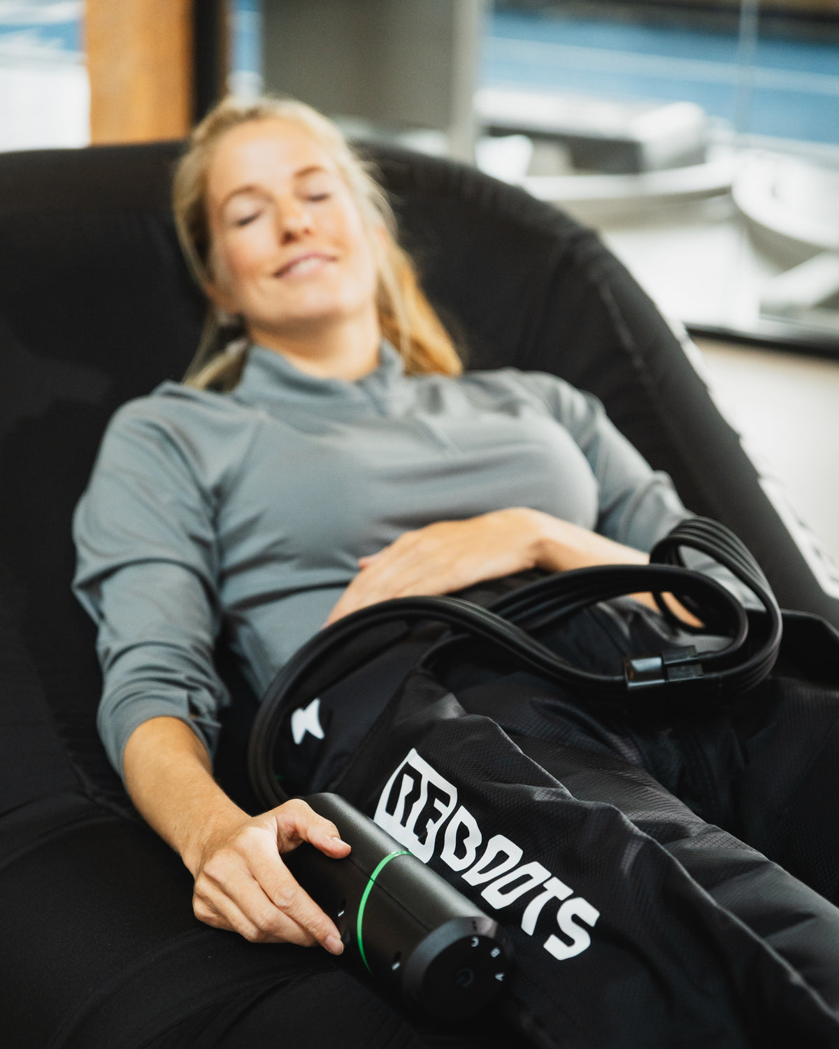Sportlerin regeneriert mit Reboots Go X auf dem Reboots Recovery Seat. 