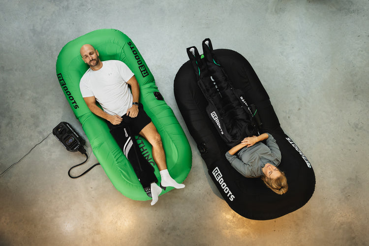 Dos atletas se recuperan simultáneamente con Reboots Recovery Seats y dispositivos de masaje de compresión.