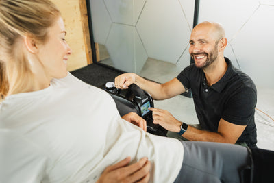 Physiotherapeut bedient Reboots Cryo Pro zur individuellen Kälte- und Kompressionstherapie bei Patientin in moderner Praxis