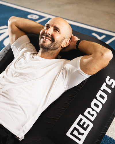 Athlet entspannt im Reboots Recovery Seat während der Regeneration mit Kompressionsmassage.